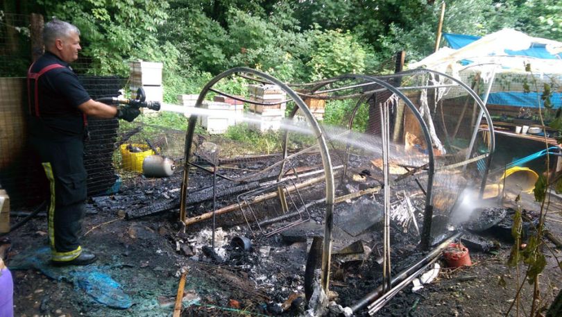 Firefighter extinguishing the burning polytunnel